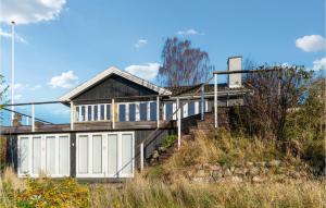 una casa con puertas blancas y escaleras en una colina en Stunning Home In Hornbk With Kitchen, en Hornbæk