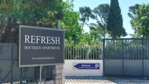 una señal frente a una puerta con una valla en Refresh Boutique Apartments, en Vodice