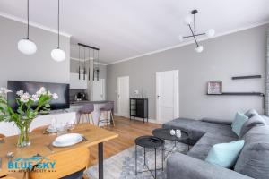 a living room with a couch and a table at Apartament Blue Sky Jelenia Góra - blisko centrum in Jelenia Góra