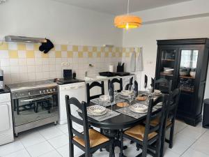 Saint-Julien-Beychevellebelle demeure médocaine charme et convivialité的厨房配有黑色的桌子和椅子 更多18张照片