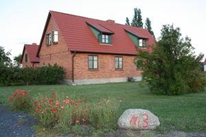 una casa con techo rojo y un patio con flores en Ferienwohnungen Dargatz, en Lüßvitz