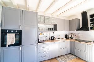 eine Küche mit weißen Schränken und weißen Geräten in der Unterkunft cottage lavanda e rosmarino in Lavis