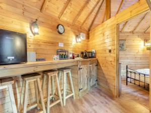 a bar in a wooden cabin with a large tv at Bear House- Uk45704 in Brinkley