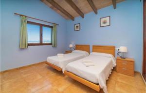 Cette chambre comprend 2 lits dans une chambre dotée de murs bleus et d'une fenêtre. dans l'établissement Villa La Mallorquina, à Sa Torre 17 autres photos