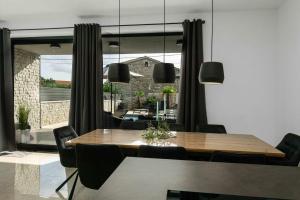 a dining room with a table and chairs and a large window at Villa More in Krk