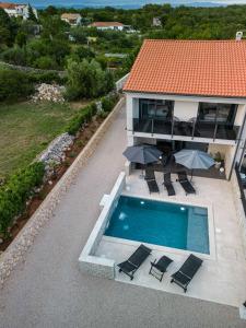 an overhead view of a house with a swimming pool and umbrellas at Villa More in Krk