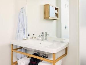 Baño blanco con lavabo y espejo en The Study at the University of Chicago en Chicago