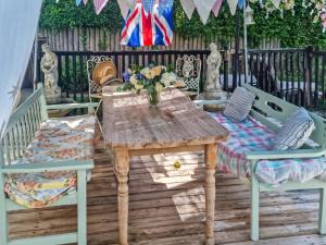 een houten tafel en twee stoelen op een terras bij Marsh Cottage in Stockbridge