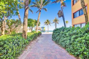 a brick walkway next to a building with palm trees at Intracoastal view Family Getaway Downtown in Hollywood