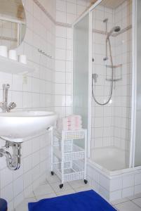 a white bathroom with a sink and a shower at Mayer Burghöfe in Owingen