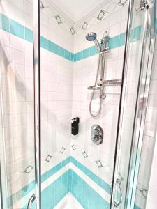 bagno con doccia e piastrelle bianche e blu di The Flowers - Casa Calicanto a Roccaraso