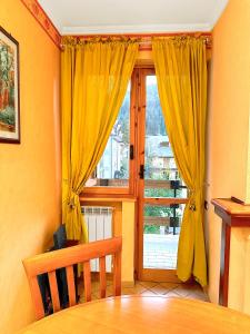a room with a window with yellow curtains at The Flowers - Casa Calicanto in Roccaraso