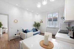 a white living room with a couch and a table at Rosa dei Venti - Centro Storico in Varazze