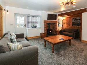 a living room with a couch and a coffee table at Y Cigydd in Derwen