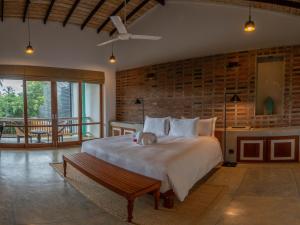 a bedroom with a large bed with a dog laying on it at Villa V Kalutara in Wadduwa
