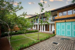 une maison avec une porte de garage bleue dans l'établissement Villa V Kalutara, à Wadduwa