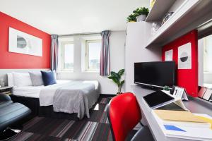 a hotel room with a bed and a desk and a tv at Modern and Comfy Studios at Corporation Village in Coventry in Coventry