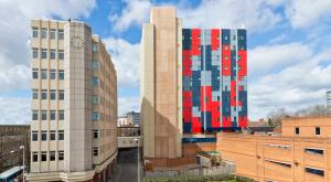 Deux grands bâtiments avec des fenêtres colorées dans une ville dans l'établissement Modern and Comfy Studios at Corporation Village in Coventry, à Coventry