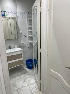 ein weißes Bad mit einer Dusche und einem Waschbecken in der Unterkunft Villa avec j'ardin in Ariana