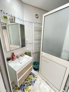 uma casa de banho com um lavatório branco e um espelho. em Villa avec j'ardin em Ariana