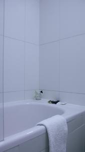a white bathroom with a towel on a bath tub at Robinson Alojamientos - Edificio María Gricelda in Ushuaia +36 photos