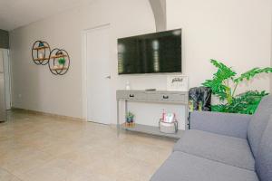 sala de estar con sofá y TV de pantalla plana en EcoMar Rentals 3/2: Cabo Rojo PR: Piscina y Playas en Cabo Rojo