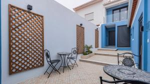 a patio with tables and chairs and a fence at Noah's Ark by LovelyStay in Cascais