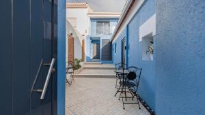 a hallway with chairs and tables in a blue building at Noah's Ark by LovelyStay in Cascais