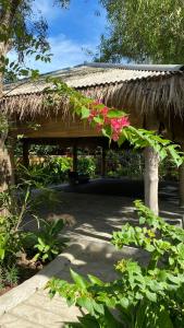 un padiglione con tetto in erba e fiori di Jepun Villa 05 - One Bedroom without kitchen a Uluwatu