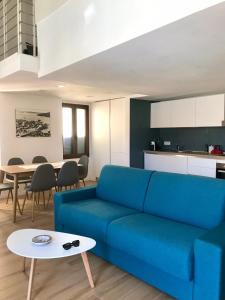 a living room with a blue couch and a table at Cala Gavetta mezzanine studio in La Maddalena