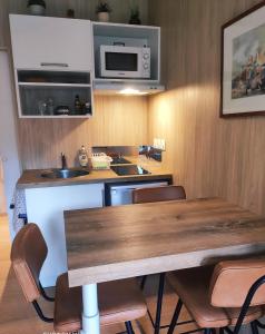 - une cuisine avec une table en bois et un four micro-ondes dans l'établissement La petite cabane de Georges à Saint Brévin l'Océan, à Saint-Brévin-les-Pins