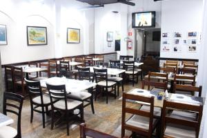 una sala da pranzo con tavoli e sedie di Hotel São Charbel a Ubatuba