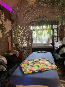 ラ・モットにあるSIANDAKI - logement romantique de charmeのベッド付きのベッドルームと木模様の壁