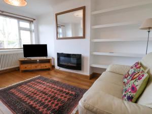 a living room with a couch and a fireplace at Rainbows End in Chester