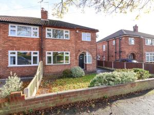 una casa di mattoni con una recinzione di fronte di Rainbows End a Chester