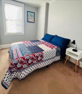 a bedroom with a bed with a quilt on it at Cozy Home close to New York City in Fairview