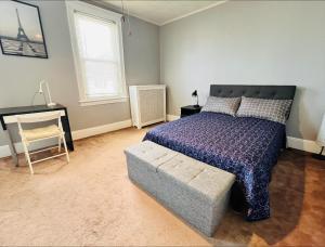 1 dormitorio con cama, silla y escritorio en Cozy Home close to New York City en Fairview