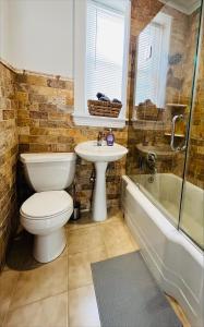 y baño con aseo, lavabo y bañera. en Cozy Home close to New York City en Fairview