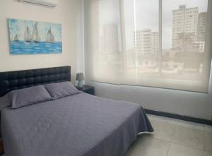 a bedroom with a bed and two windows at Hermoso departamento duplex en Salinas Chipipe in Salinas