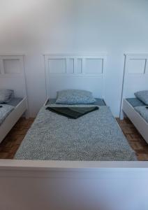 a white room with two beds and a large bed at HOSTEL VANEČA in Puconci