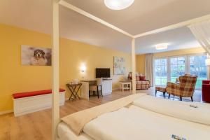 ein Schlafzimmer mit einem Bett und ein Wohnzimmer in der Unterkunft Hotel Landhaus Ellerbrock in Sankt Peter-Ording