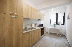 a kitchen with wooden cabinets and a sink at Vitan Central Oasis - NEW Building - FREE Secured Private PARKING - Self Check-in - in Bucharest