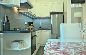 波雷奇的住宿－Tatty，厨房配有白色橱柜和一张带葡萄酒玻璃的桌子