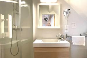 La salle de bains est pourvue d'un lavabo et d'une douche. dans l'établissement La Villa Les Mots Passants, à Cabourg