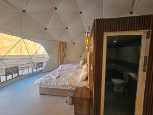 a bedroom with a bed with a large umbrella at Star Camp Wadi Rum in Wadi Rum