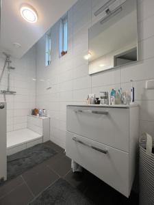 een witte badkamer met een wastafel en een bad bij Stadslogement Goudsteeg 19B in Zwolle
