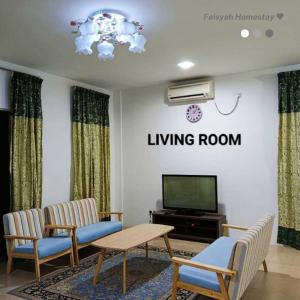 - un salon avec deux chaises et une télévision dans l'établissement FAISYAH HOMESTAY, à Lahad Datu