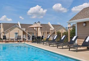 una piscina con tumbonas y sombrilla en Sonesta ES Suites Wilmington - Newark, en Newark