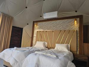 duas camas sentadas uma ao lado da outra numa tenda em Star Camp Wadi Rum em Wadi Rum