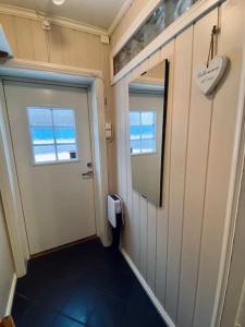 een hal met een deur, een raam en een spiegel bij Sentralt og hjemmekoselig in Narvik